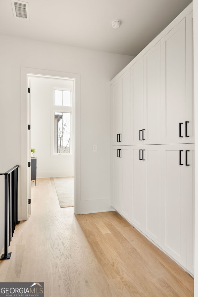 clothes washing area featuring light hardwood / wood-style flooring