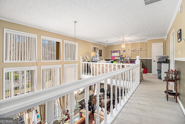 hallway with light carpet, crown molding, and a textured ceiling