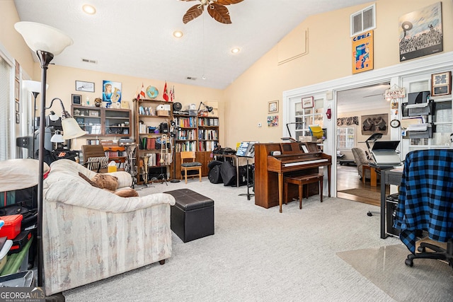 carpeted home office with ceiling fan and high vaulted ceiling