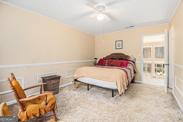 carpeted bedroom featuring ceiling fan and a textured ceiling