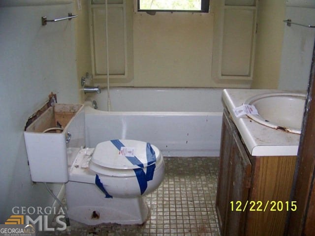 bathroom with vanity, toilet, a bathtub, and tile patterned flooring