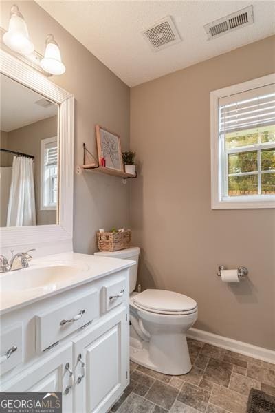 bathroom with a shower with curtain, vanity, and toilet