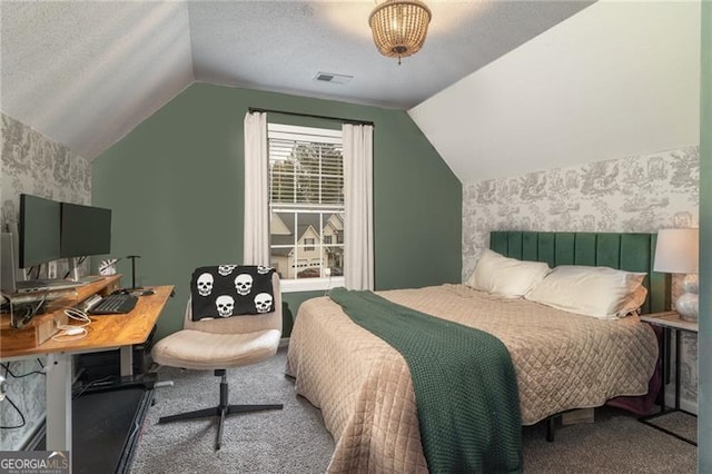 bedroom with lofted ceiling, carpet floors, and a textured ceiling