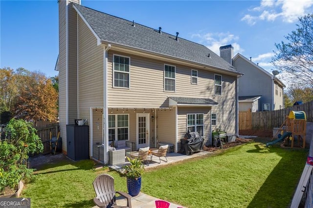 rear view of house with a playground, a patio area, and a yard