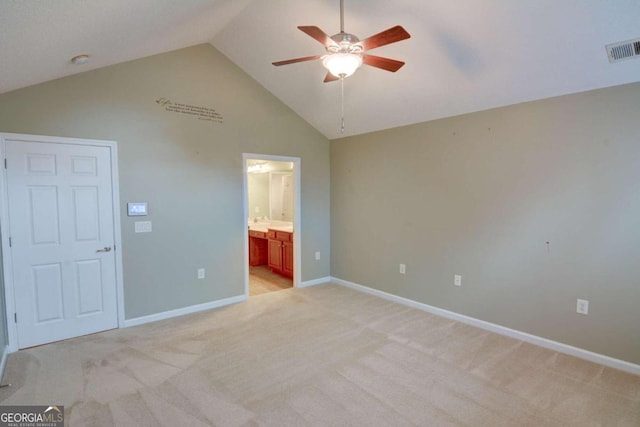 unfurnished bedroom featuring ensuite bath, ceiling fan, high vaulted ceiling, and light colored carpet