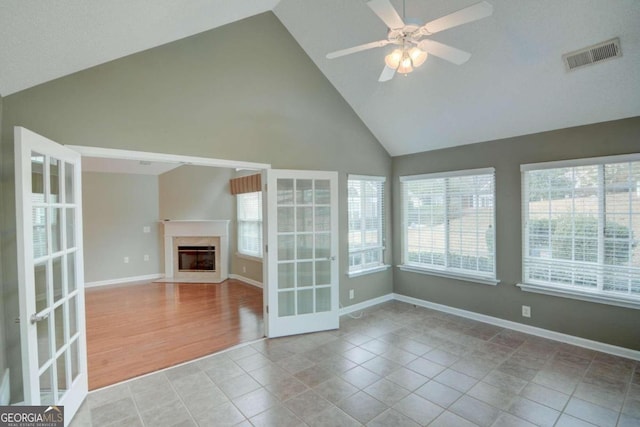 unfurnished living room featuring french doors, high vaulted ceiling, light hardwood / wood-style flooring, and ceiling fan