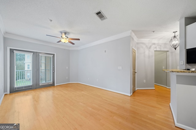 unfurnished living room with ceiling fan with notable chandelier, a textured ceiling, light hardwood / wood-style flooring, and crown molding