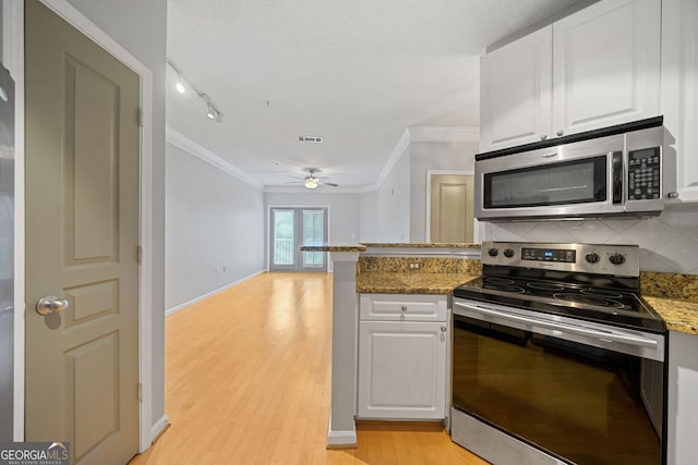 kitchen featuring white cabinetry, backsplash, appliances with stainless steel finishes, and light hardwood / wood-style flooring