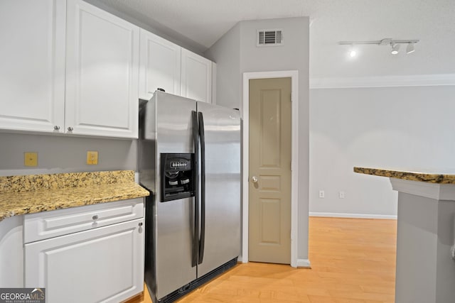 kitchen featuring white cabinets, stainless steel fridge, a textured ceiling, light hardwood / wood-style floors, and light stone counters