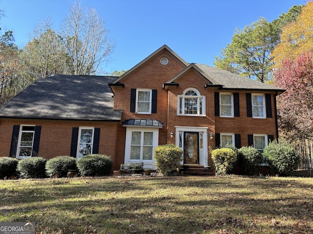 colonial-style house featuring a front yard