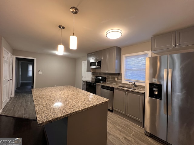 kitchen with appliances with stainless steel finishes, sink, gray cabinetry, and wood-type flooring