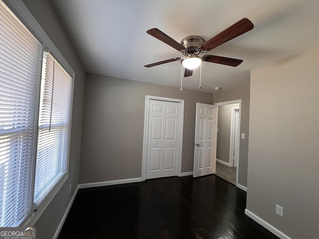 unfurnished bedroom with ceiling fan, dark hardwood / wood-style floors, and a closet