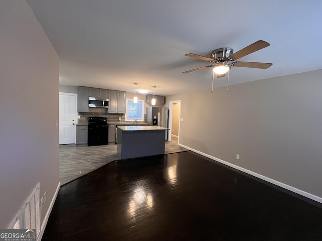 unfurnished living room with ceiling fan and dark wood-type flooring