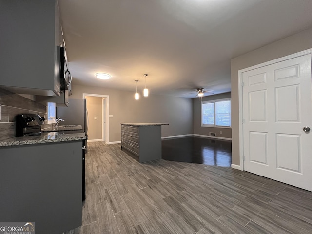 kitchen featuring stone counters, dark hardwood / wood-style flooring, decorative light fixtures, and ceiling fan