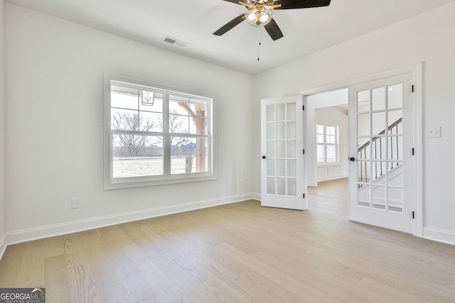 spare room with french doors and light hardwood / wood-style flooring