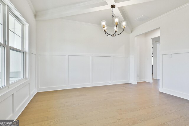 spare room featuring a wealth of natural light, beamed ceiling, coffered ceiling, and a notable chandelier