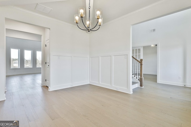 unfurnished room featuring ornamental molding, light hardwood / wood-style flooring, and a chandelier