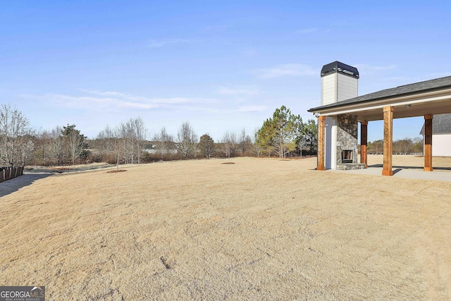 view of yard featuring an outdoor stone fireplace