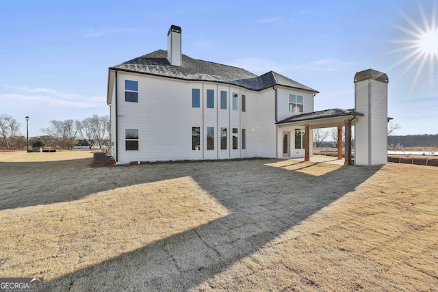 rear view of house with a lawn and central AC unit