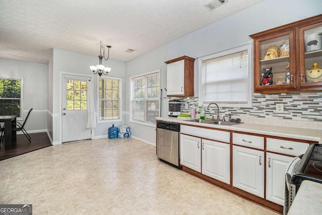 kitchen with tasteful backsplash, stainless steel dishwasher, sink, pendant lighting, and a notable chandelier