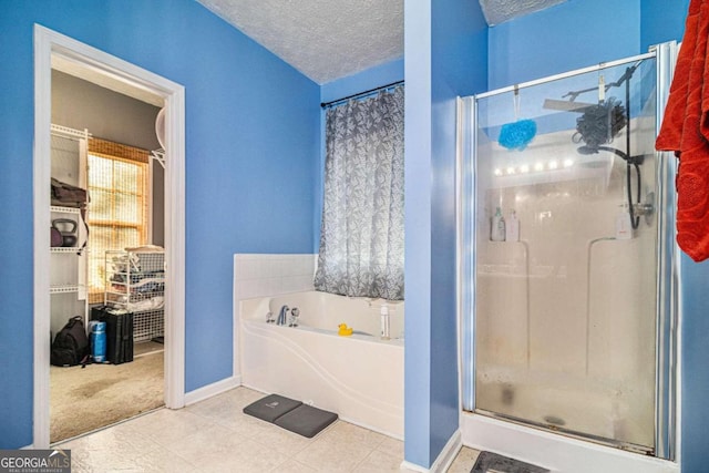 bathroom with separate shower and tub, tile patterned floors, and a textured ceiling