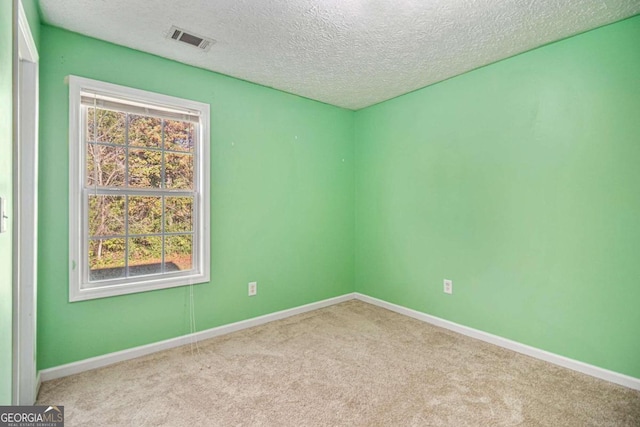 carpeted spare room with a textured ceiling