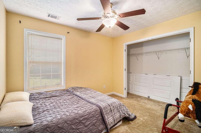 bedroom featuring carpet flooring, a textured ceiling, a closet, and ceiling fan