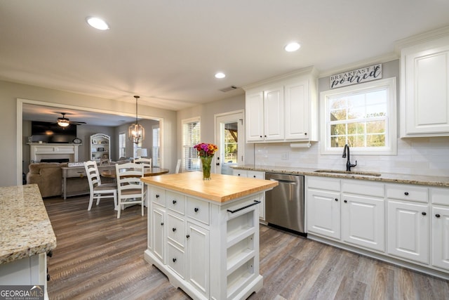 kitchen with dishwasher, decorative light fixtures, white cabinetry, and sink