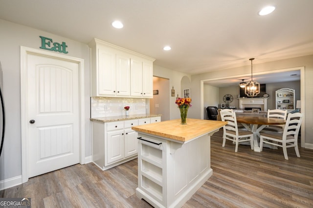 kitchen featuring a center island, white cabinets, wooden counters, and hardwood / wood-style flooring