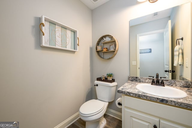 bathroom with vanity, hardwood / wood-style flooring, and toilet