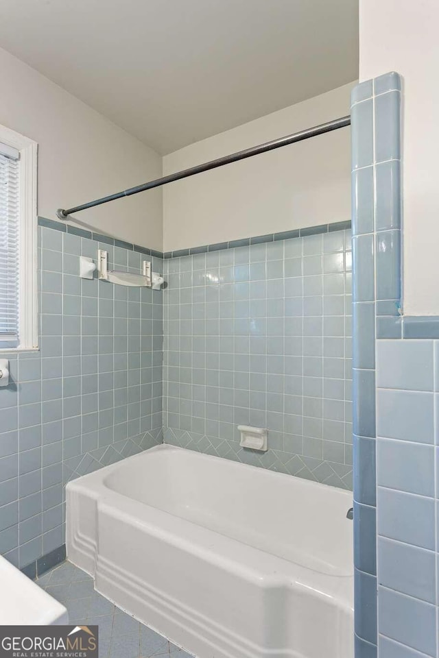 bathroom featuring tile walls, tile patterned flooring, and tiled shower / bath combo