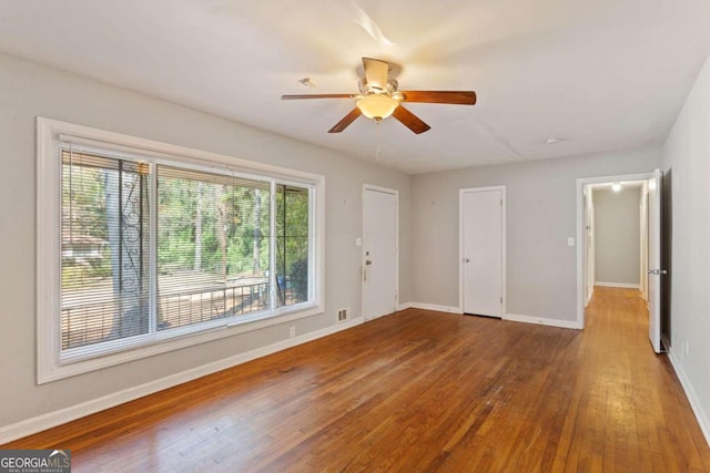 empty room featuring ceiling fan and hardwood / wood-style floors