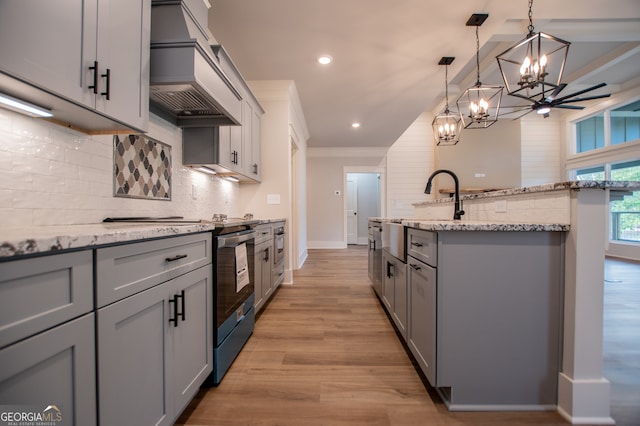 kitchen with decorative light fixtures, gray cabinetry, custom range hood, and light wood-type flooring