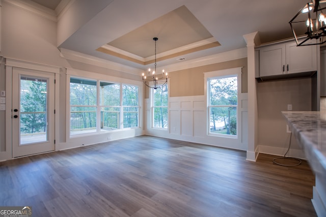 unfurnished dining area with dark hardwood / wood-style flooring, plenty of natural light, and a notable chandelier