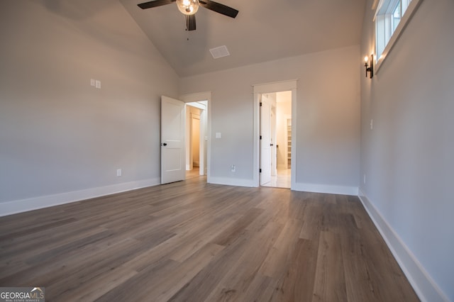 unfurnished bedroom with ceiling fan, hardwood / wood-style floors, and high vaulted ceiling