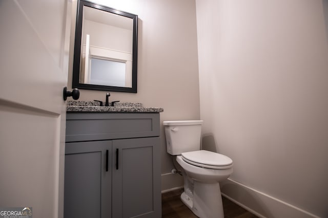 bathroom featuring hardwood / wood-style floors, vanity, and toilet