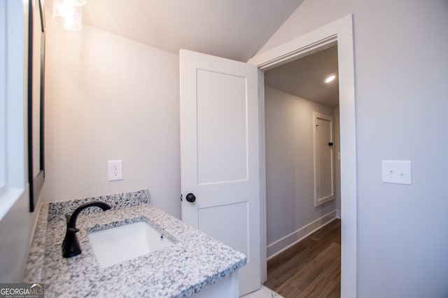 bathroom with vanity, hardwood / wood-style flooring, and lofted ceiling