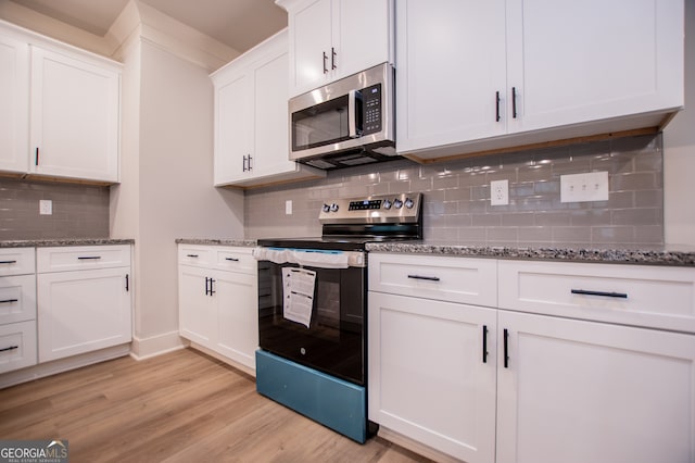 kitchen featuring electric stove, decorative backsplash, white cabinets, and light hardwood / wood-style floors