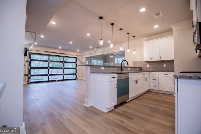 kitchen featuring light hardwood / wood-style flooring, kitchen peninsula, white cabinetry, and dishwasher