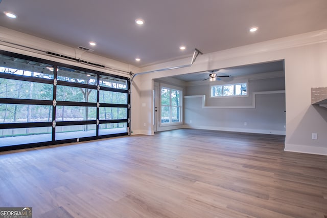 unfurnished living room featuring ceiling fan, hardwood / wood-style floors, and ornamental molding