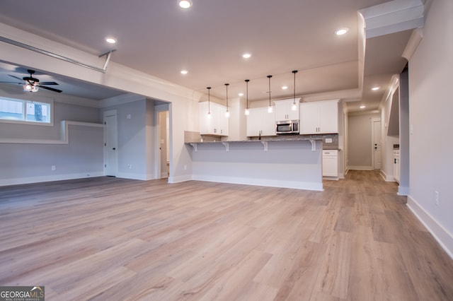 kitchen with kitchen peninsula, white cabinetry, ceiling fan, and light wood-type flooring