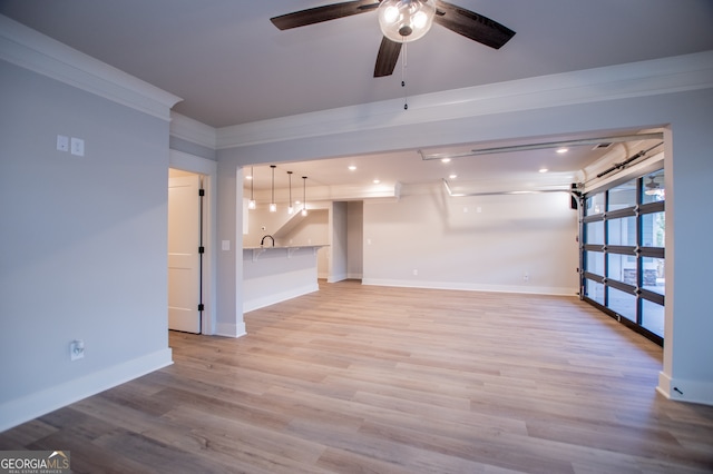 unfurnished living room with light hardwood / wood-style flooring, ornamental molding, and ceiling fan