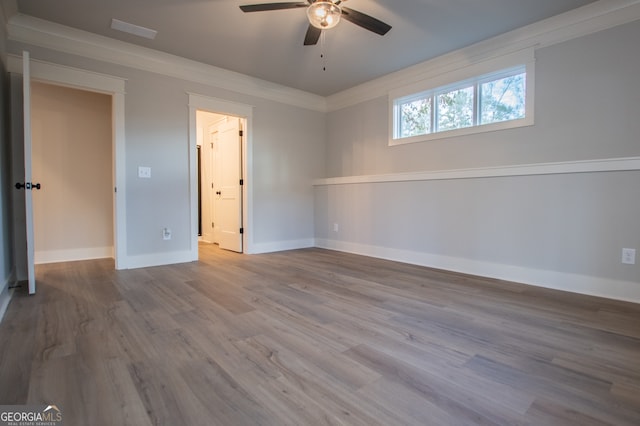 interior space with hardwood / wood-style flooring, ceiling fan, and ornamental molding