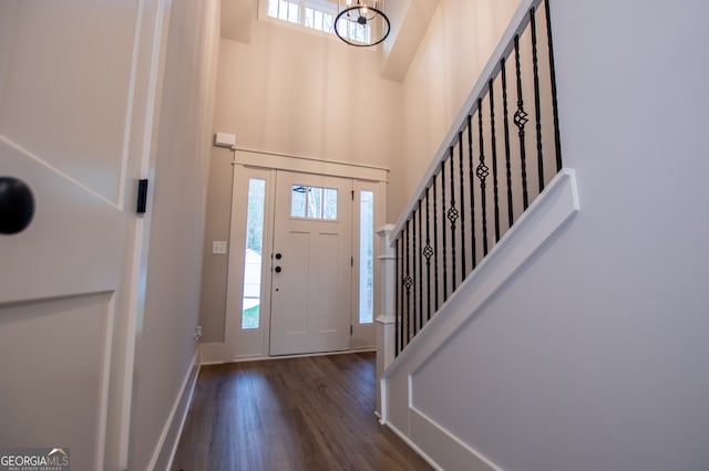 entryway with a towering ceiling, dark hardwood / wood-style flooring, and a healthy amount of sunlight