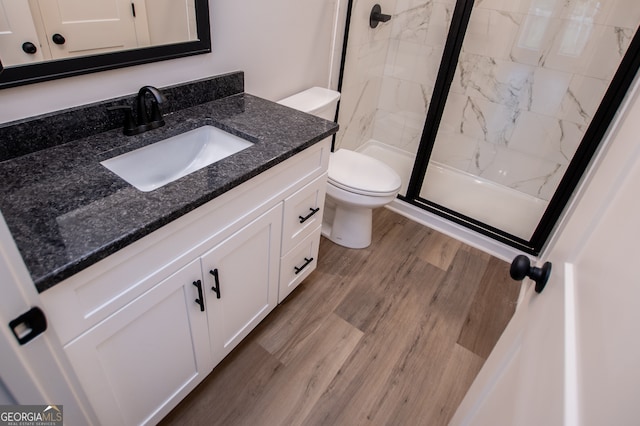 bathroom featuring vanity, hardwood / wood-style floors, toilet, and a shower with door