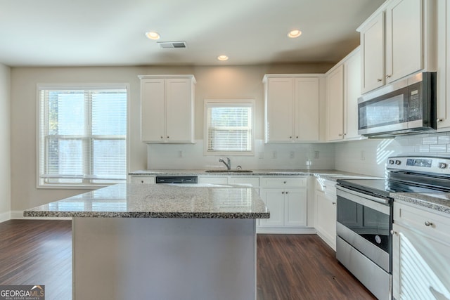 kitchen featuring sink, stainless steel appliances, light stone countertops, and white cabinetry