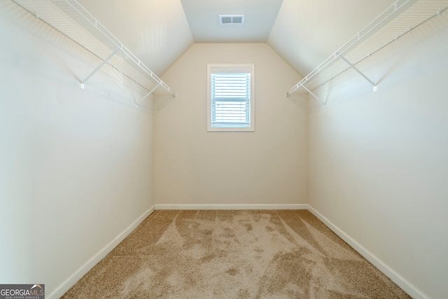 walk in closet with lofted ceiling and carpet floors