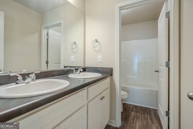 full bathroom with hardwood / wood-style floors, bathtub / shower combination, vanity, and toilet