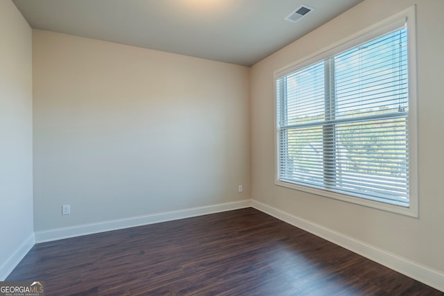 unfurnished room with dark wood-type flooring