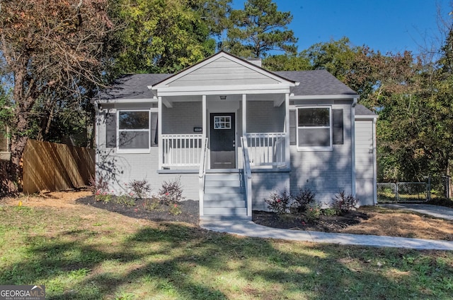 bungalow-style house featuring a front lawn and covered porch